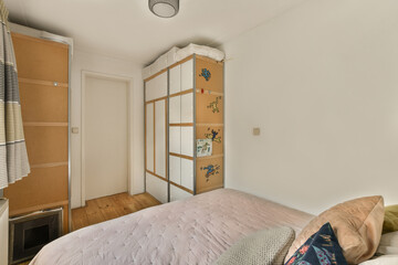 a bedroom with a bed and cupboards on the wall in front of the bed is an open door that leads to...