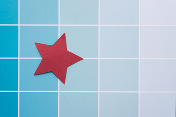 red paper star on blue paper pad sheet with paint-chip style coloration