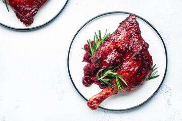 Baked duck legs in cherry red wine sauce with rosemary. Delicacy dinner. White table background,...