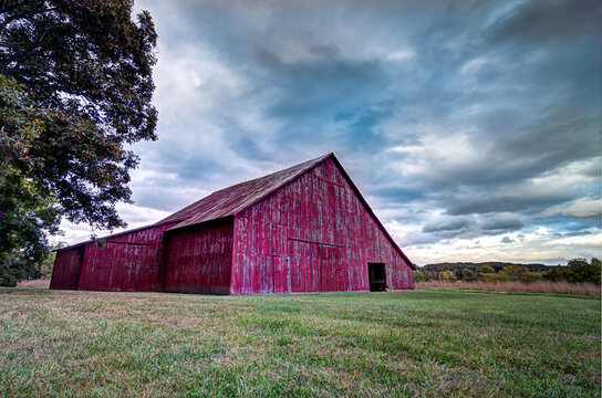 Red Barn in a Field with Storm Clouds Forming Above