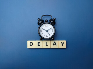Black alarm clock with the word DELAY