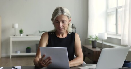 Overjoyed mature woman get great news written in paper letter, read received information, notice or statement from bank, celebrate salary growth, income increase, enjoy promotion, loan approval, bonus