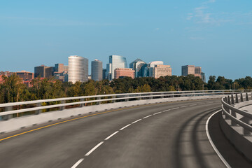 Fototapeta premium Empty urban asphalt road exterior with city buildings background. New modern highway concrete construction. Concept way to success. Transportation logistic industry fast delivery. Arlington. USA.
