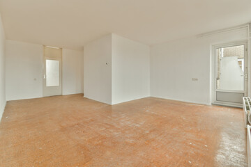 an empty room with white walls and wood flooring in the middle of the room, there is a door leading...