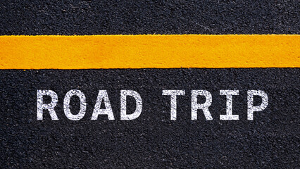 Fototapeta premium The word road trip on asphalt and yellow line road. Concept for travel.