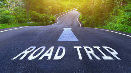 The word road trip on empty asphalt curve country road. Concept for travel.