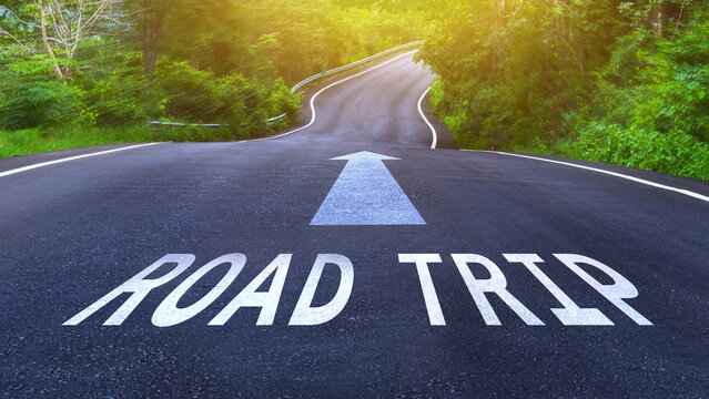 The word road trip on empty asphalt curve country road. Concept for travel.