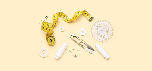 Set of sewing supplies on light yellow background
