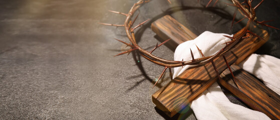 Crown of thorns, wooden cross and shroud on grey background with space for text