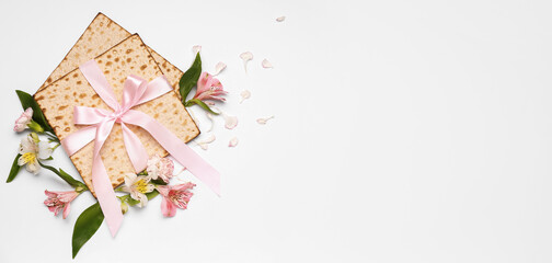 Jewish flatbread matza for Passover and flowers on light background with space for text