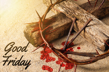 Crown of thorns, cross, nails and text GOOD FRIDAY on sand
