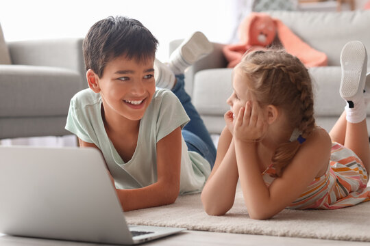 Little boy and girl watching cartoons on laptop at home