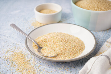 Plate with amaranth seeds on light background