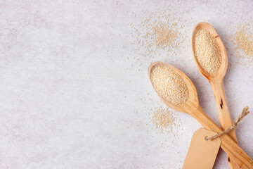 Wooden spoons of amaranth seeds on light background