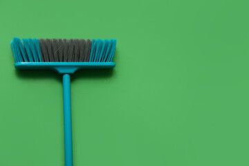 Blue cleaning broom on green background