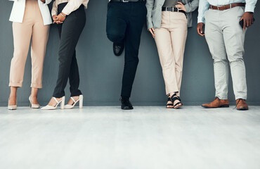Fototapeta na wymiar Legs, waiting room and group of people for interview, recruitment or job opportunity on wall background. Shoes, candidates and men with women on mockup for work hiring, process and company startup