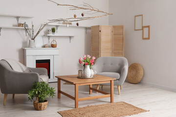 Interior of living room decorated for Easter celebration with armchairs and tree branches