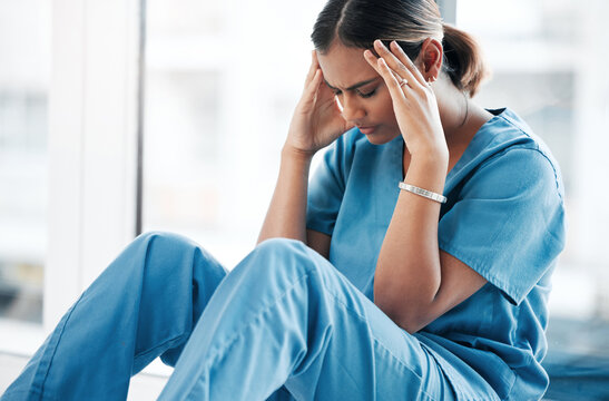 Burnout, stress and medical with nurse on floor of hospital for sad, mental health and headache. Anxiety, depression and frustrated with tired woman in clinic for healthcare, medicine and nursing