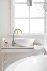 Fototapeta na wymiar Interior of bathroom with ceramic sink and reed diffuser near window