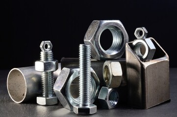 composition of nuts bolts and scraps of metal laid out on a dark background.