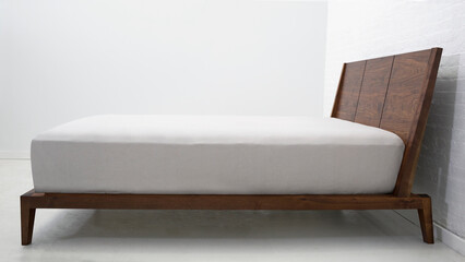 Modern wooden double bed, bed with white bed linen and curtains
