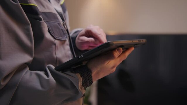 Close up shot of installer sets up security camera in house using digital tablet computer and app. Worker checks internet speed after installation. Installation of wireless local area network. WLAN.