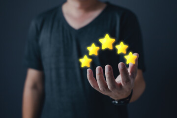 hand of customer or client holding the stars to complete five stars with copy space.Service rating,giving a five star rating.satisfaction concept.