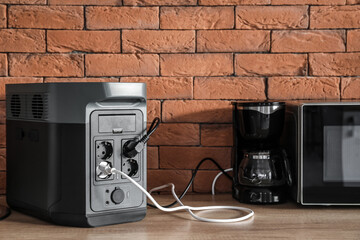 Coffee machine and microwave oven plugged in portable power station on counter in kitchen