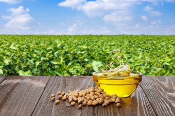 soy seeds falling in splashing soybean oil in glass bowl on wooden table