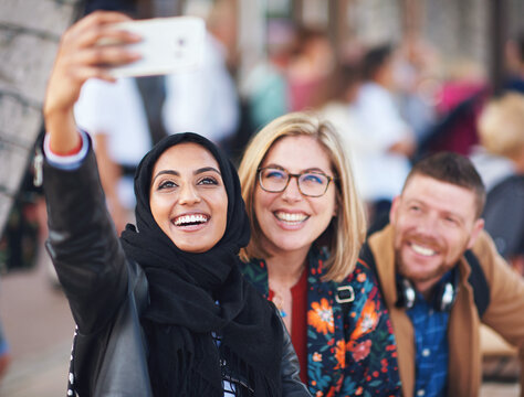Friends selfie, muslim woman and city with smile, man and happiness with smartphone on social media. Young gen z people, phone and profile picture for urban adventure in metro for outdoor photography