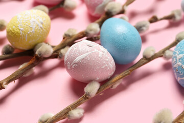 Composition with willow branches and beautiful Easter eggs on pink background, closeup