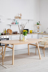 Interior of kitchen with Easter decor, white counters and dining table
