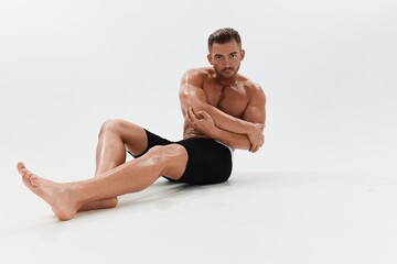 Man athletic body bodybuilder in briefs with naked torso abs full-length in the background, fitness classes. Advertising, sports, active lifestyle, competition, challenge concept.