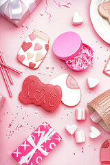 Composition with tasty cookies, gifts, marshmallows and straws on pink background. Valentine's Day celebration