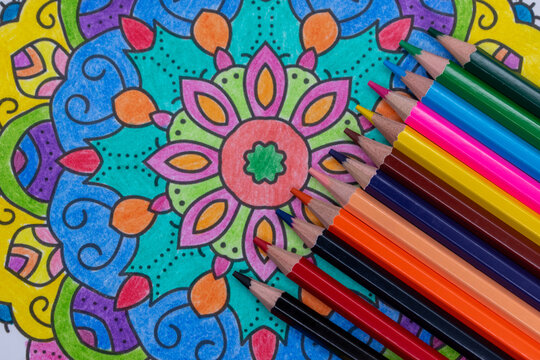 Finishing coloring a mandala in the shape of a flower, art, mindfulness, love, stress relief, selective focus