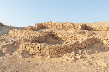 The remains  of internal buildings in the rays of the rising sun in the ruins of the fortress of Masada - is a fortress built by Herod the Great on a cliff-top off the coast of the Dead Sea, Israel