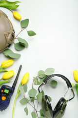 Frame made of military equipment, eucalyptus and tulips on light background. Hello spring