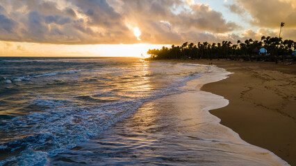 aerial drone image of beautiful beach during sunset in Punta Cana. the golden sunset feels the sky...