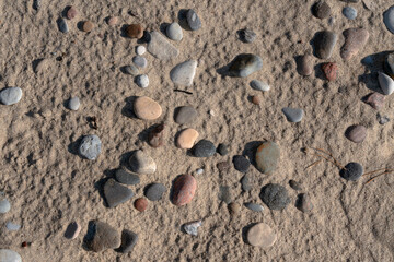 Colorful sea pebbles on the sand of the beach on the Baltic Sea, Curonian Spit, Kaliningrad region, Russia