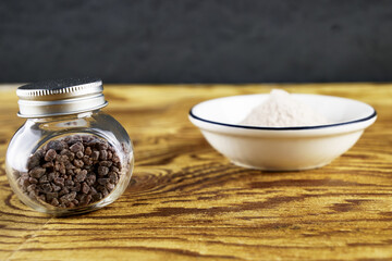 Black salt Kala namak in a glass salt shaker and on a plate on a wooden table