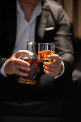 Businessman sitting and holding glass of whiskey