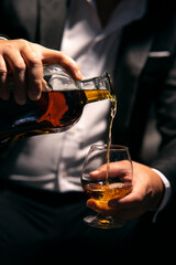 Fototapeta na wymiar Businessman sitting and holding glass of whiskey