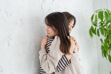 抱きしめ合う2人の女性