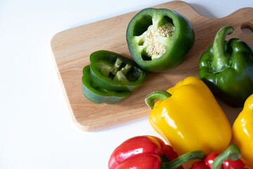 Top view of cutting sweet bell pepper on the wooden board isolated on white background.
