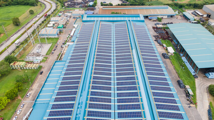 Aerial view of blue photovoltaic solar panels rooftop. Construction Solar panels or Solar cells on industrial factory rooftop. Production of sustainable energy or green ecological electricity concept.