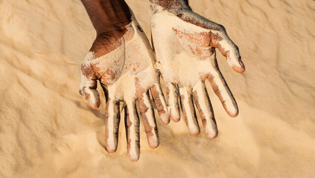 Climate change. Man holding sand in his hands. Symbolic representation of desertification and drought. Photo