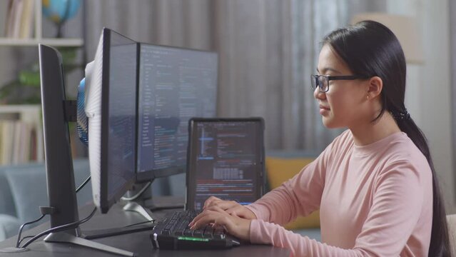 Asian Teen Girl Programmer With A Tablet Creating Software Engineer Developing App, Program, Video Game On Desktop Computer At Home. Terminal With Coding Language 
