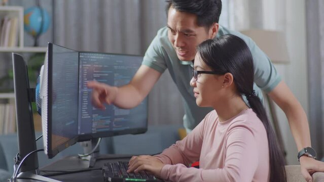 Asian Teen Girl Students Studying Software Code From Male Teacher Or Father
