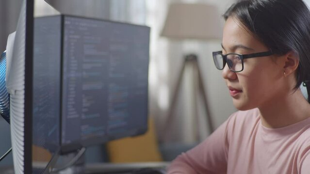 Close Up Of Asian Teen Girl Programmer Having A Headache Creating Software Engineer Developing App, Program, Video Game On Desktop Computer At Home. Terminal With Coding Language 
