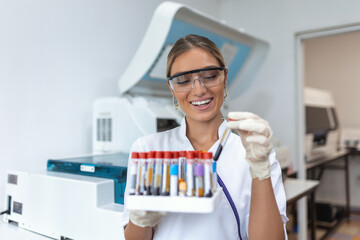 Technician holding blood tube test in the research laboratory. Coronavirus testing. Doctor taking a...